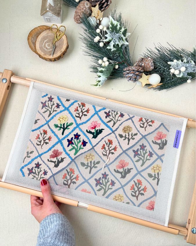 a girl stitching a needlepoint christmas stocking canvas