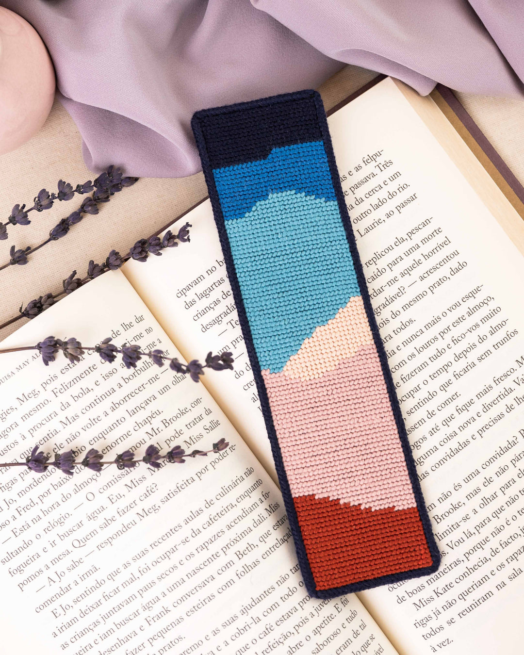 nightfall mountains needlepoint bookmark finished and placed on top of an open book