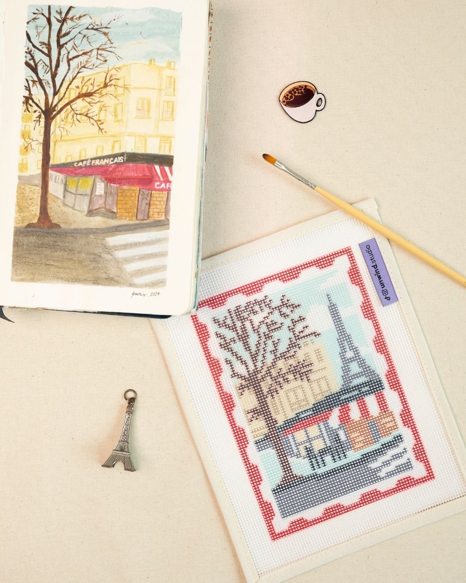 Paris stamp/postcard needlepoint canvas placed next the watercolor sketch that inspired this design