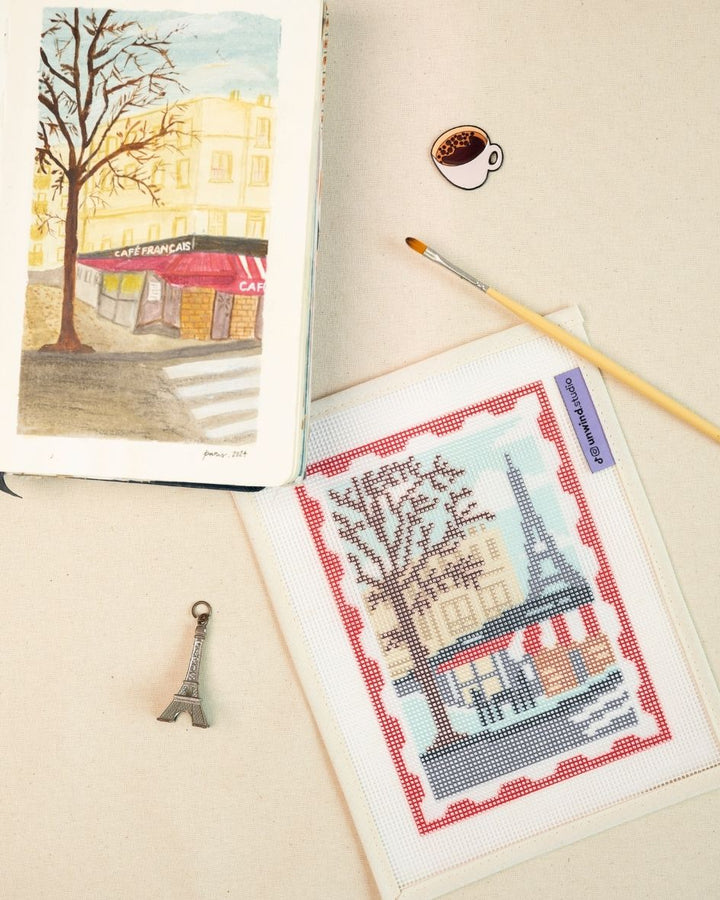 Paris stamp/postcard needlepoint canvas placed next the watercolor sketch that inspired this design