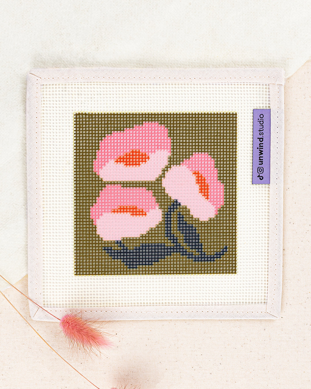 Pink Poppies Coaster needlepoint kit by diana pereira: printed canvas of pink flowers on green, framed with dried twigs