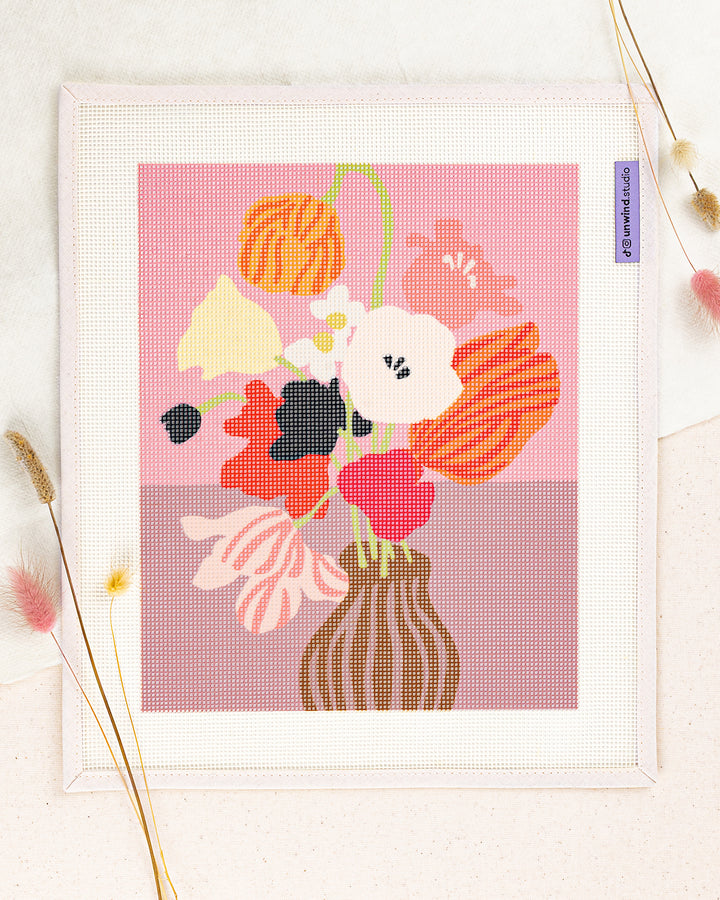 Pink Table needlepoint kit by Ophelia Pang: printed canvas of pink flowers on blue, framed with dried twigs