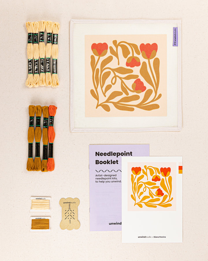 Poppy Tangle needlepoint kit contents: printed canvas, threads, needles, and instruction booklet, graphic flyer laid flat