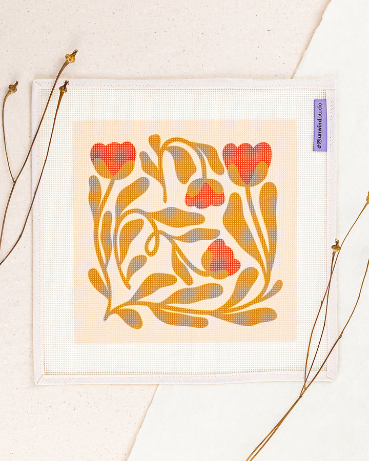 Poppy Tangle needlepoint kit by diana pereira: printed canvas of yellow flowers on blue, framed with dried twigs