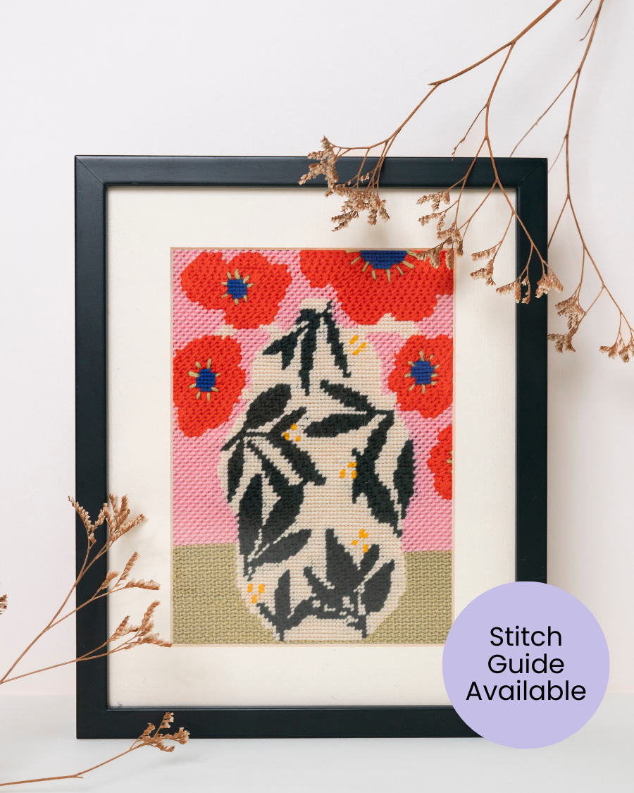 Poppy Pot by Unwind Studio placed in a black wood frame with dry flowers as decorations.