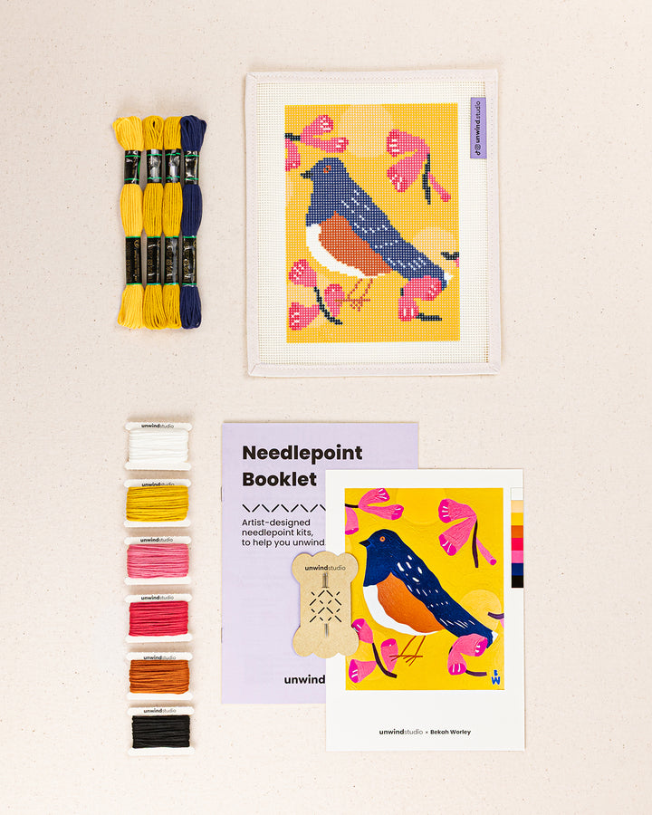 spotted towhee needlepoint kit contents: printed canvas, threads, needles, and instruction booklet, graphic flyer laid flat