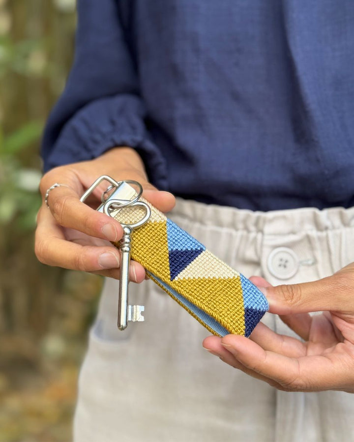 Summit Key Fob with a key being held by a pair of hands on a blue shirt background

