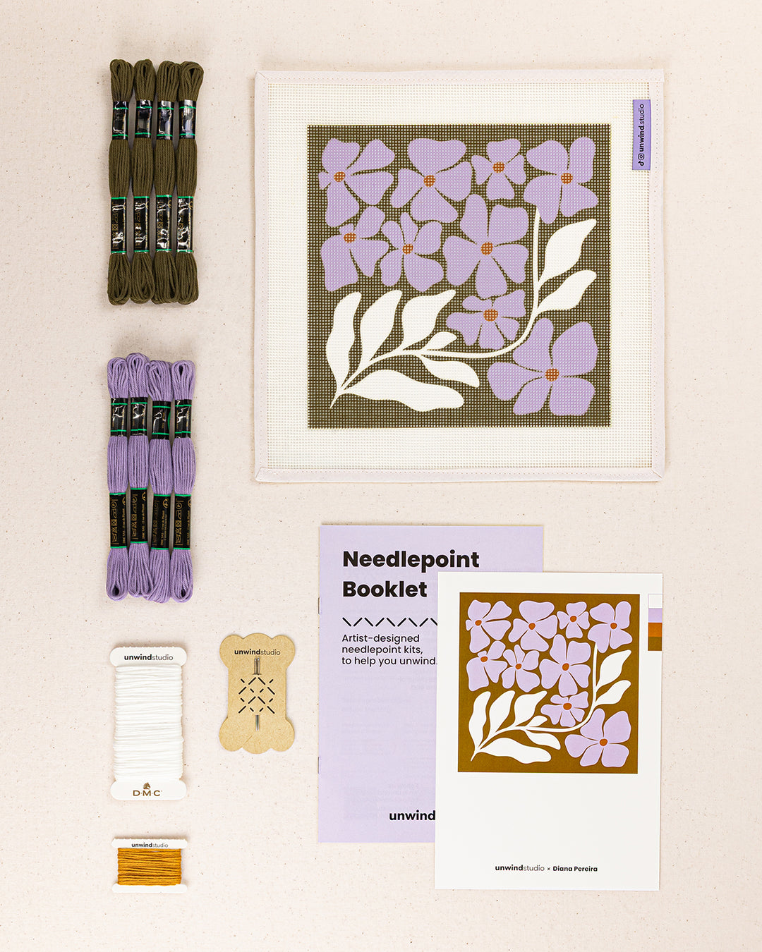 wildflowers needlepoint kit contents: printed canvas, threads, needles, and instruction booklet, graphic flyer laid flat