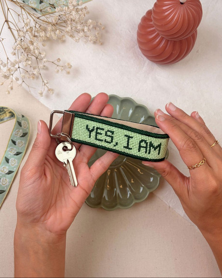 "yes, i am" needlepoint key fob finished with a ket set and matching decorative elements surrounding