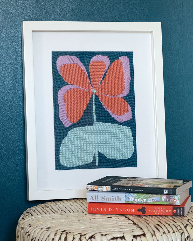 Framed needlepoint with illustration of colorful flower