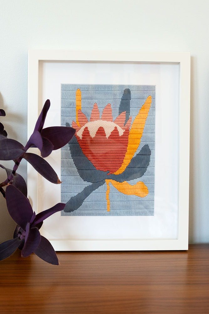 framed needlepoint with illustration of big flower