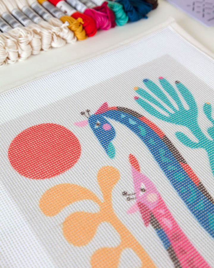Needlepoint canvas with illustration of mom and child giraffes mom and child