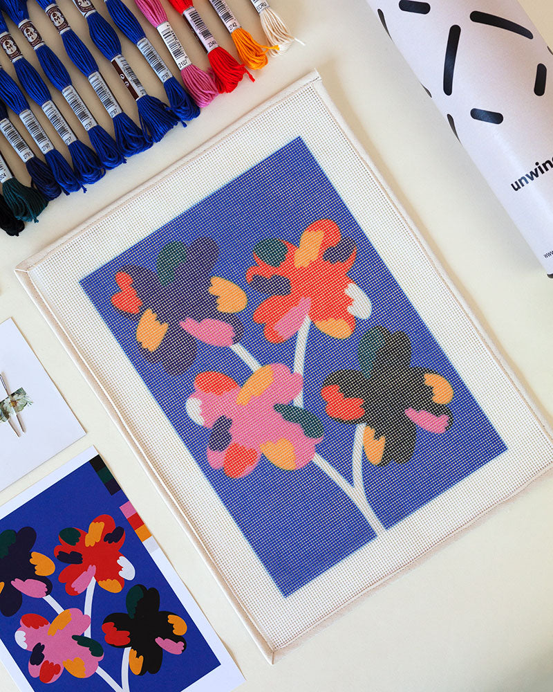 Needlepoint canvas with illustration of four colorful flowers