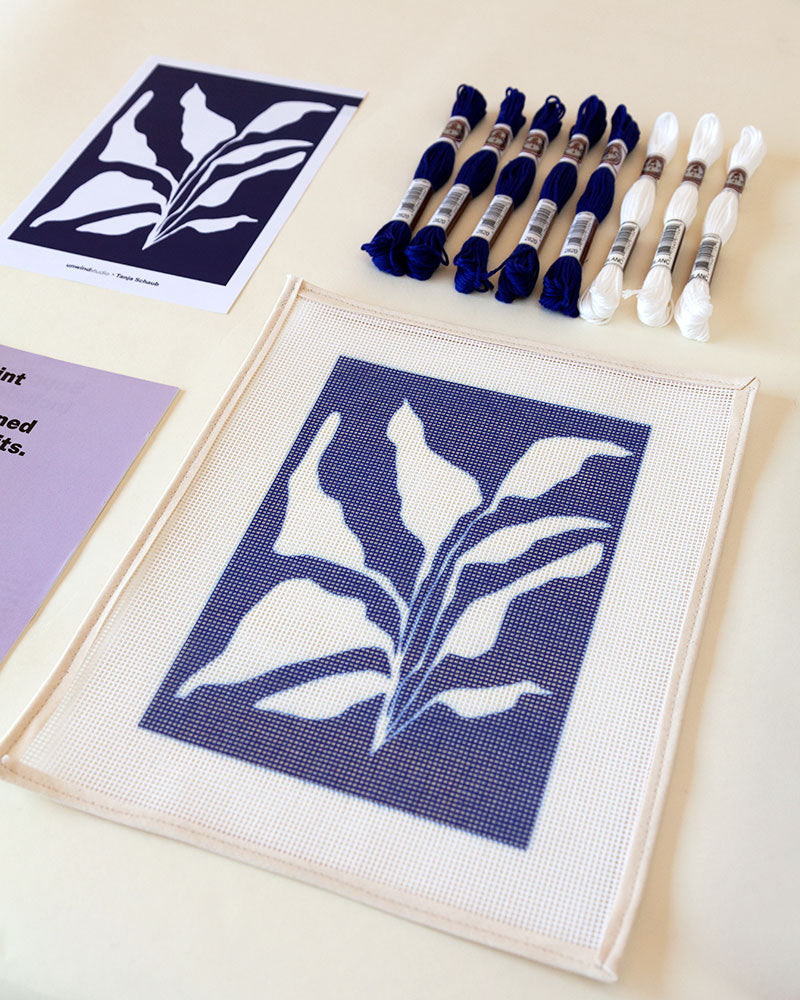 Needlepoint kit with illustration of white plant in blue background